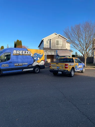 Breeze Heating, Air, and Electrical trucks parked in front of a house, Seattle, WA. Learn about our Referral Program and how you can earn rewards.