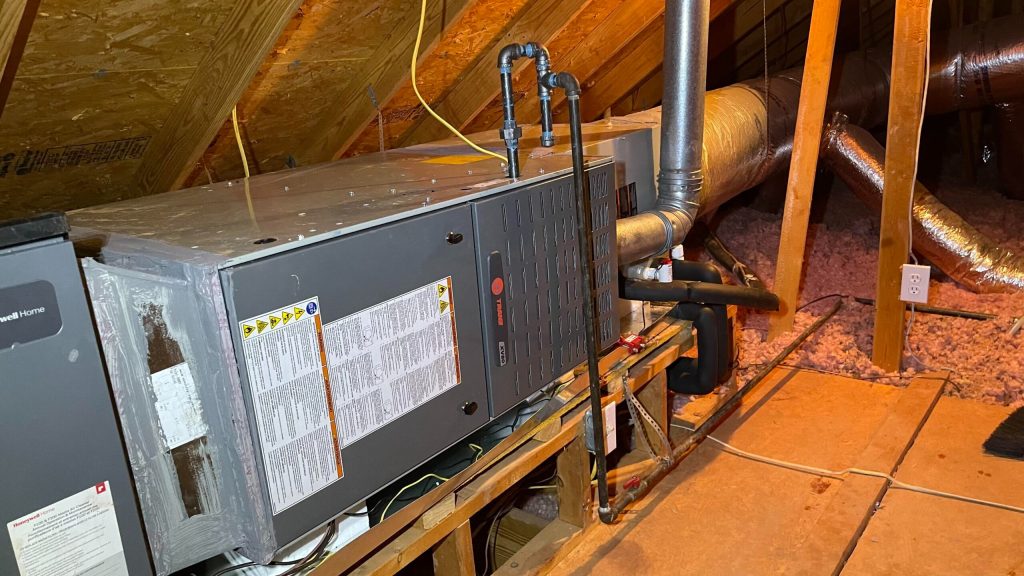 Air handler unit in attic with ductwork and insulation, showcasing HVAC installation for improved airflow and energy efficiency in homes across Kent, WA.