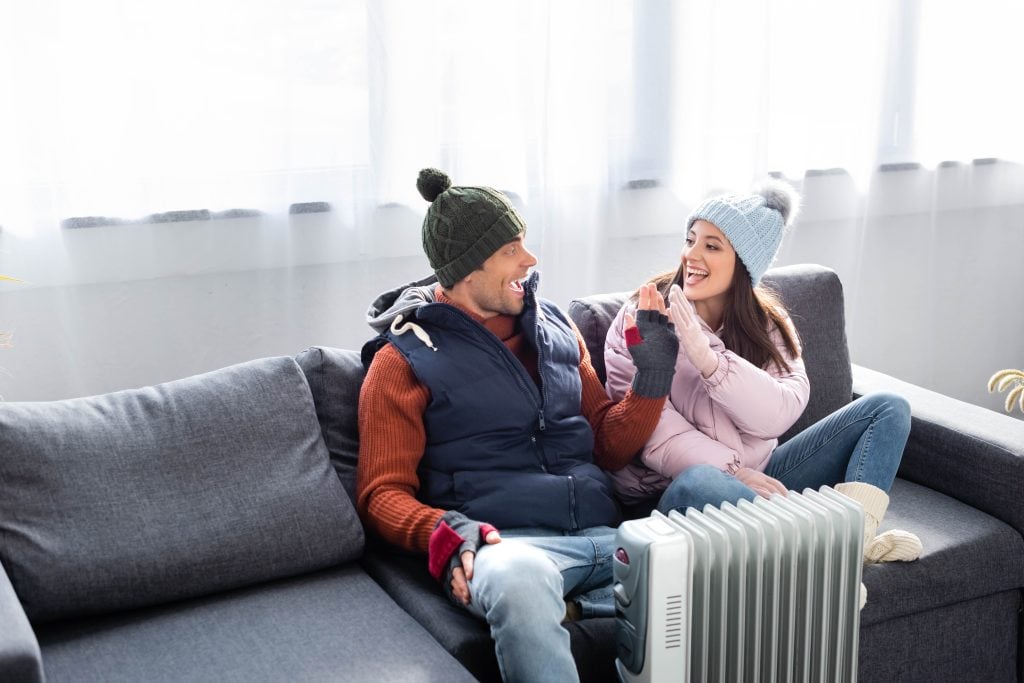 Couple enjoying warmth from heater after Heating Maintenance & inspection in Seattle, WA. Winter safety and comfort at home with reliable heat.