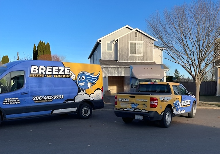 Breeze Heating and Electrical service vans parked outside a home, showcasing their residential service in Seattle, WA. Reliable home solutions.