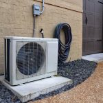 Ductless heat pump installed outside a Kent home on a concrete pad, next to a brick wall and garage door, ideal for homes without ductwork.