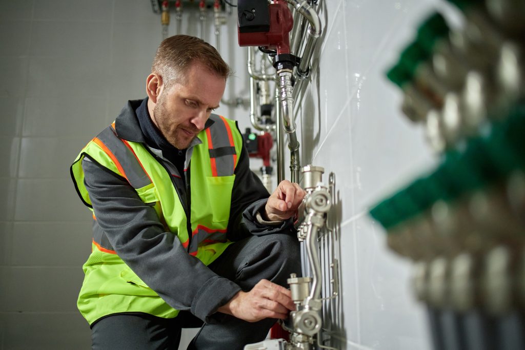 Heating Installation: Technician inspecting plumbing during a heating system replacement. Quality service in Seattle, WA, for home comfort.