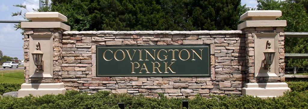 Entrance to Covington Park with a stone sign and manicured landscaping, creating a welcoming, upscale feel. Covington community in mind.