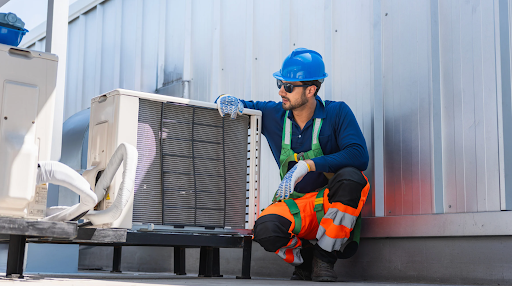HVAC technician in Bellevue, WA, wearing a hard hat and safety vest, inspecting an outdoor AC unit. Find trusted HVAC contractors here.